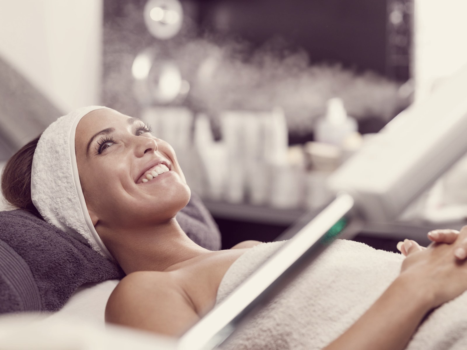 Woman relaxing under a steam facial at a med spa
