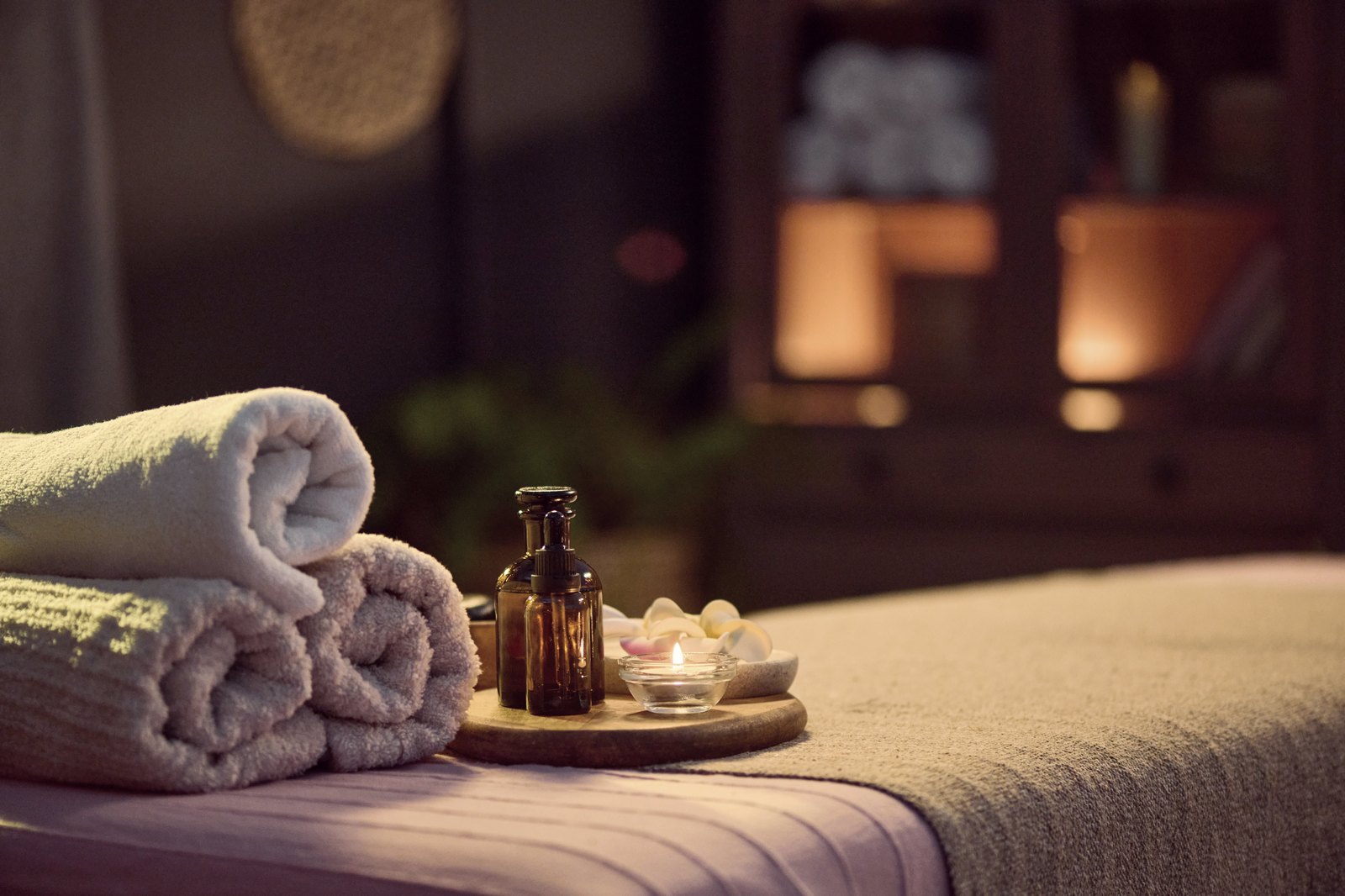 Calm spa arrangement with a lit candle and folded towels