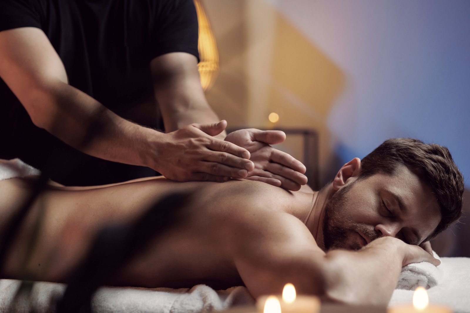 Client receiving a relaxing massage in a candle-lit spa room